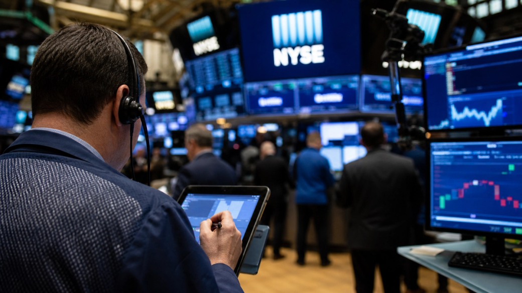 The image shows a trader at the New York Stock Exchange (NYSE) engaged in monitoring market data with a tablet. Multiple screens display financial charts and trading information, creating a dynamic trading environment.