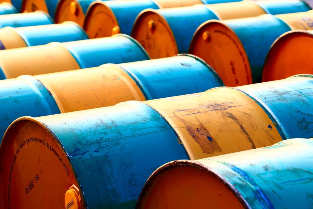 The image showcases a close-up view of numerous blue and yellow barrels arranged in rows. The barrels are cylindrical and appear to be used for storage, likely of liquids or chemicals. — Credit: Photo by Atik sulianami on Unsplash