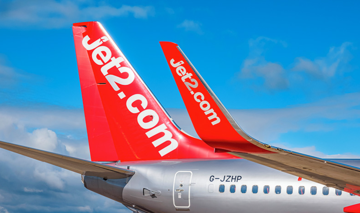 The image features the tails of two Jet2.com aircraft, showcasing their distinct red fuselage and white branding. The sky in the background is mostly clear, highlighting the aircraft's design.