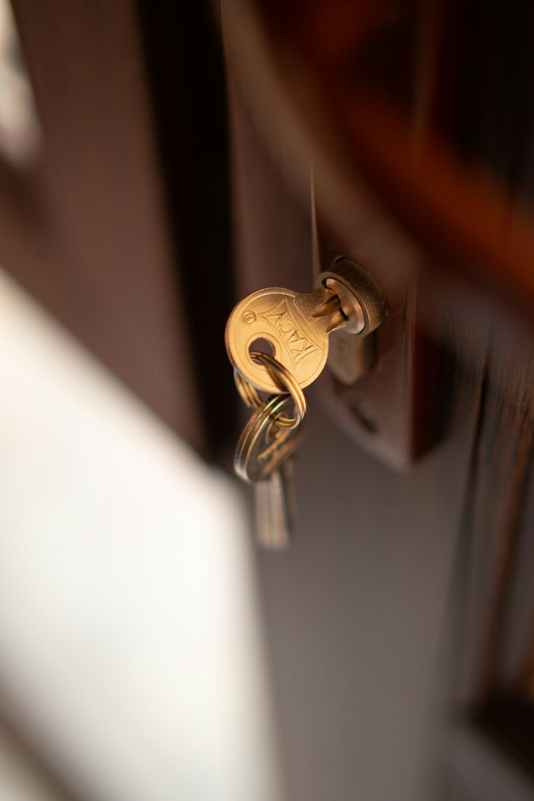 The image features a close-up of a door with a key inserted into the lock. The golden key is hanging from a keyring, emphasizing the concept of access and security.