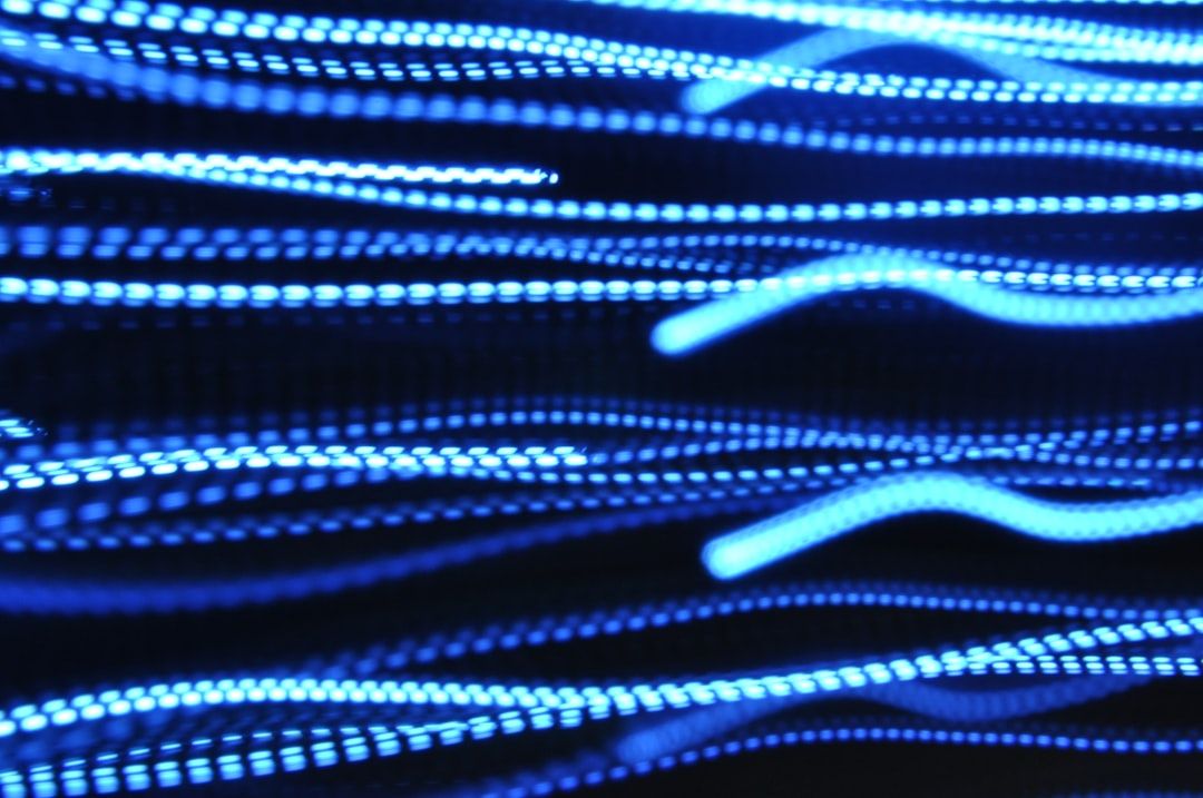 The image features a dynamic display of blue light streaks, creating a sense of motion and energy. The abstract composition suggests themes of technology and modernity.