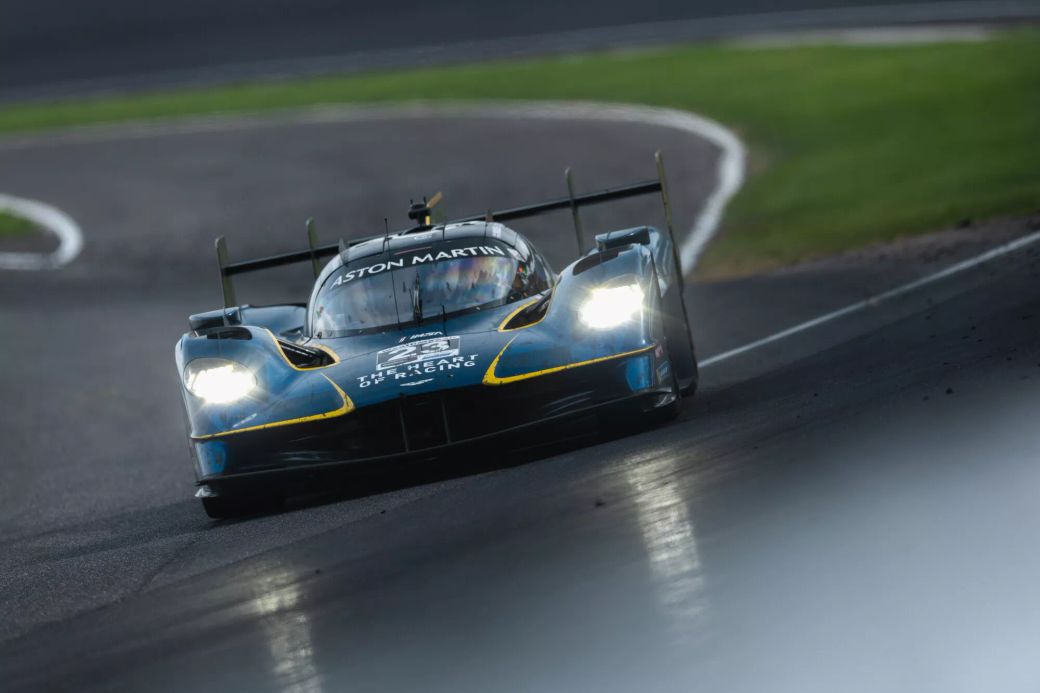 A sleek Aston Martin racing car navigates a winding track with precision. The vehicle is designed for high-speed performance, showcasing its aerodynamic features in a competitive racing environment.