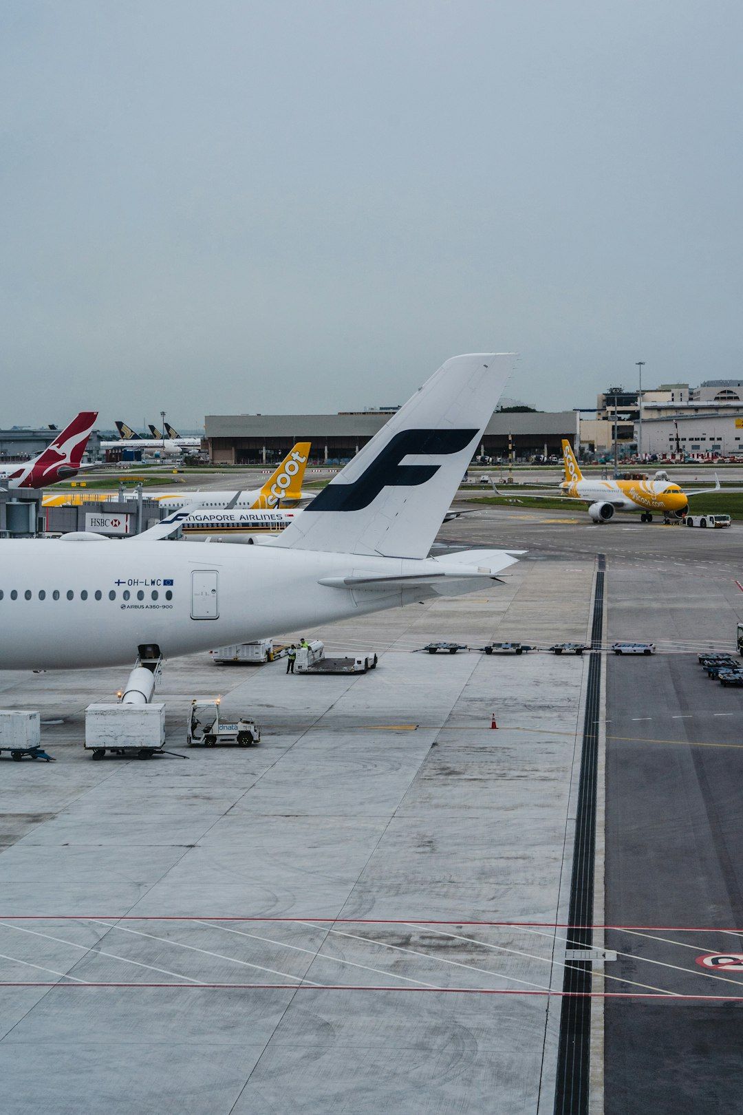 The image captures a view of an airport runway with several aircraft parked and taxiing. A Finnish Airlines airplane is prominently displayed in the foreground, alongside other airline jets in the background, indicating a busy airport environment.