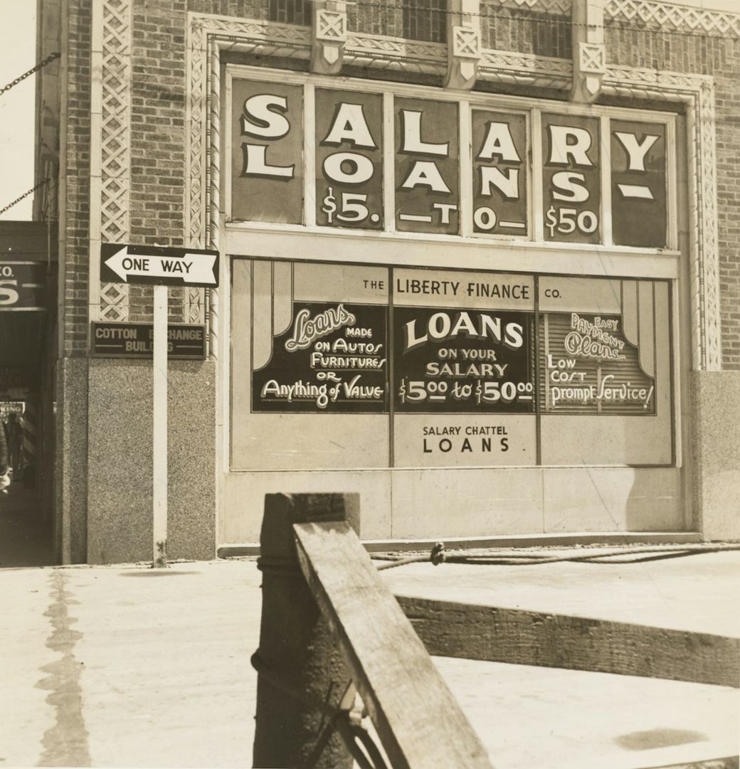 The image shows a vintage storefront for a loan company, featuring large signage advertising salary loans ranging from $5 to $50. The building displays additional promotions and information about loans on various collateral. — Credit: Photo by The New York Public Library on Unsplash