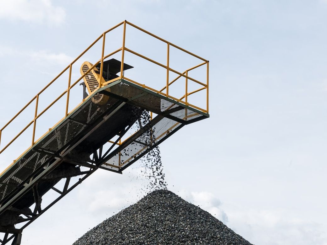 a large pile of gravel being loaded onto a truck — Credit: Photo by Adriano on Unsplash
