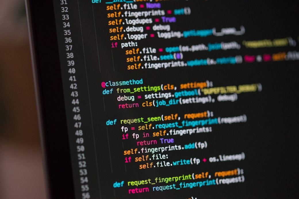 The image displays a close-up view of a computer screen showcasing lines of computer code. The code appears to be written in Python, indicating various functions and definitions. — Credit: Photo by Chris Ried on Unsplash