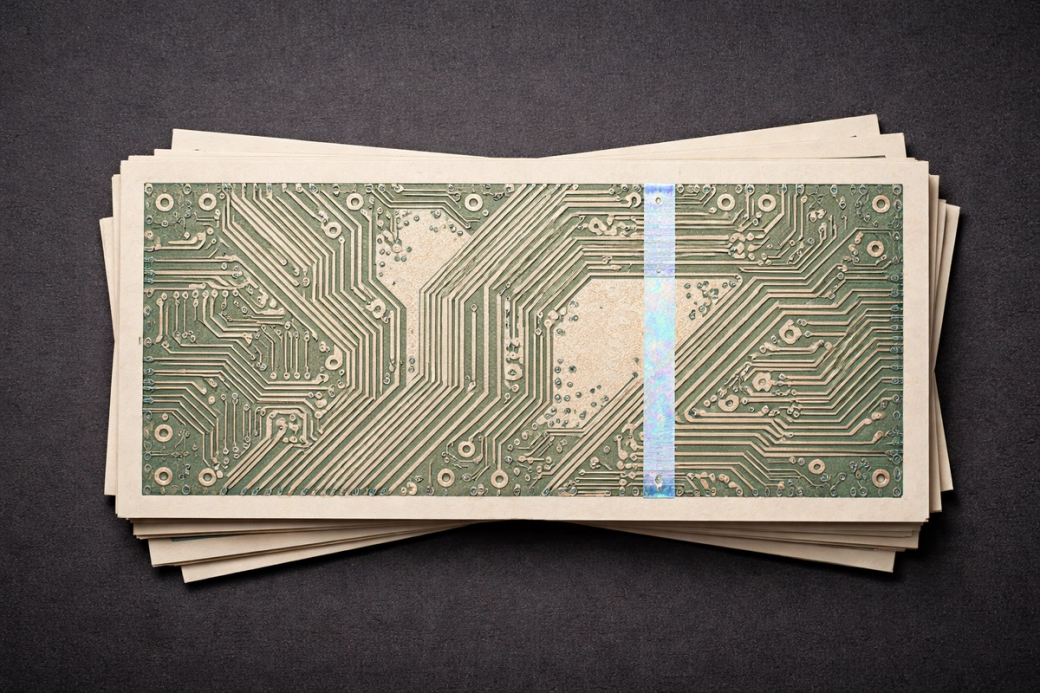 Tech money, notes that look like circuits. The image features a stack of circuit boards arranged neatly on a dark textured surface. The circuit boards display intricate patterns and electronic components, suggesting a focus on technology and design.