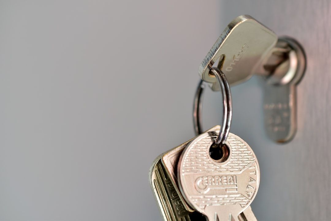 The image features a close-up of a key attached to a keychain, placed in a lock. The focus is on the details of the key and its surroundings, highlighting the metal texture.