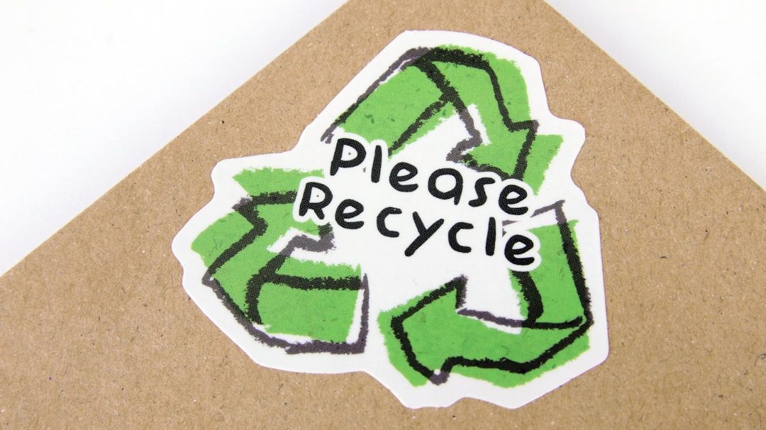 The image features a sticker with the recycling symbol and the text 'Please Recycle' prominently displayed. The design emphasizes a commitment to environmental sustainability.