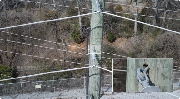 photo of powerline pole with focus on a weak point in the attachment of the line