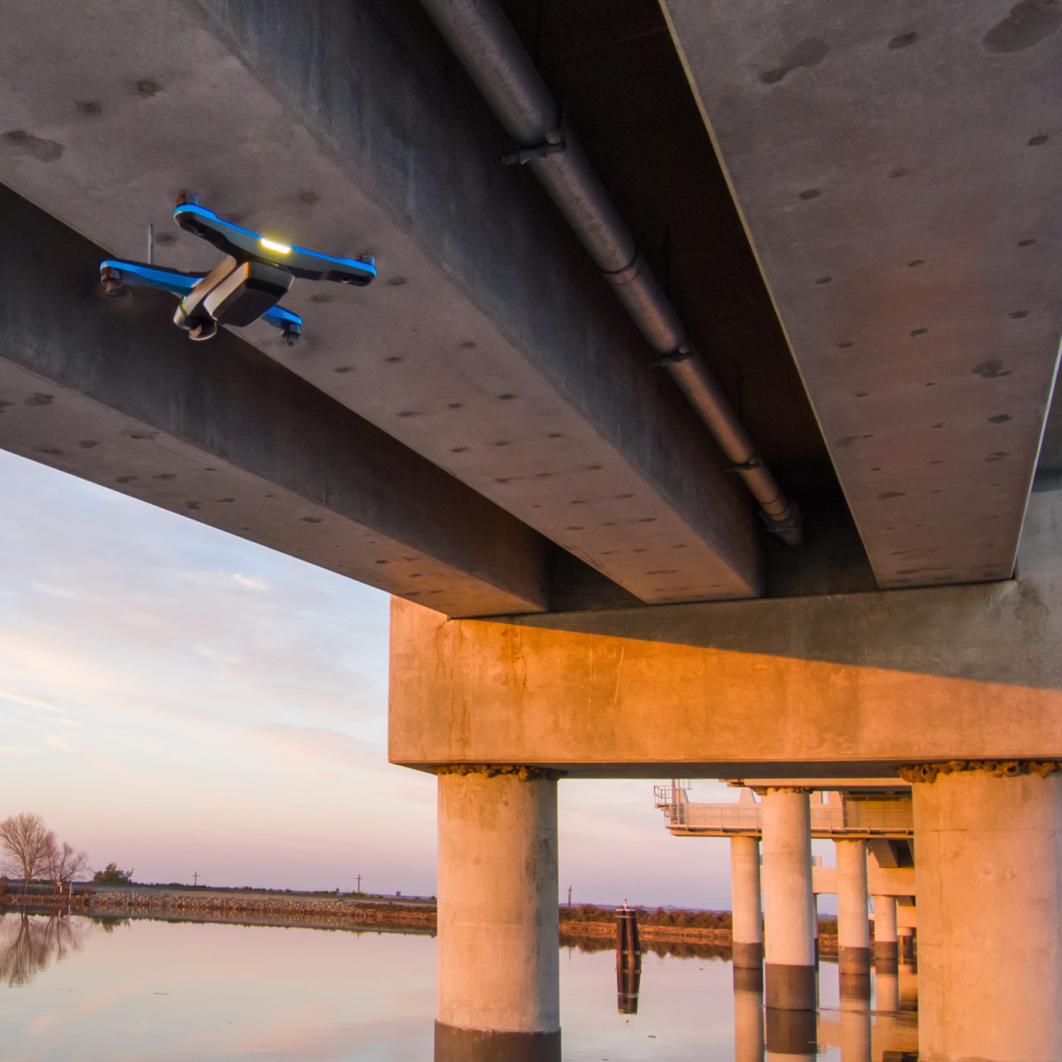 Skydio 2+ drone flying underneath a bridge