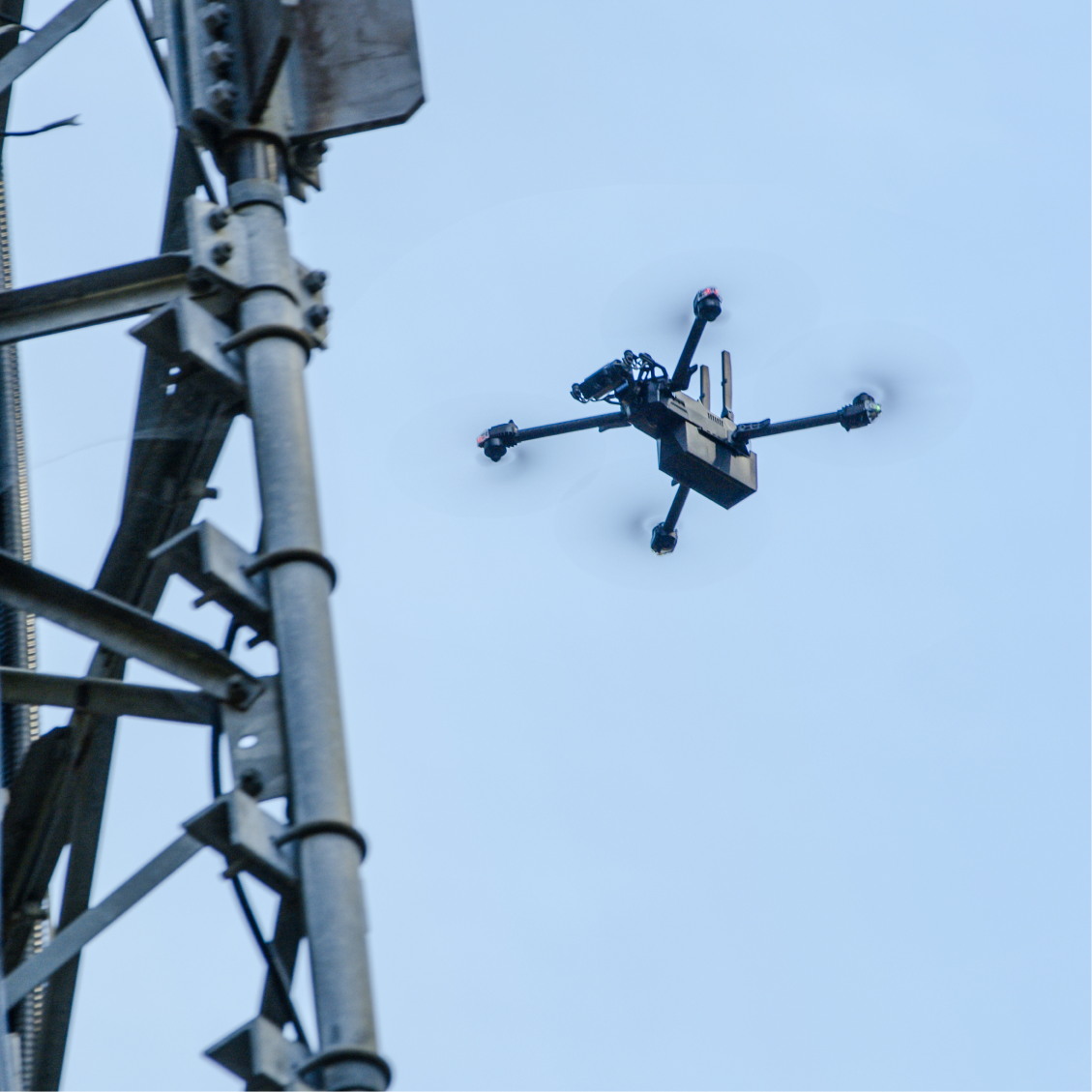 Drone in flight around cell tower inspecting telecoms equipment