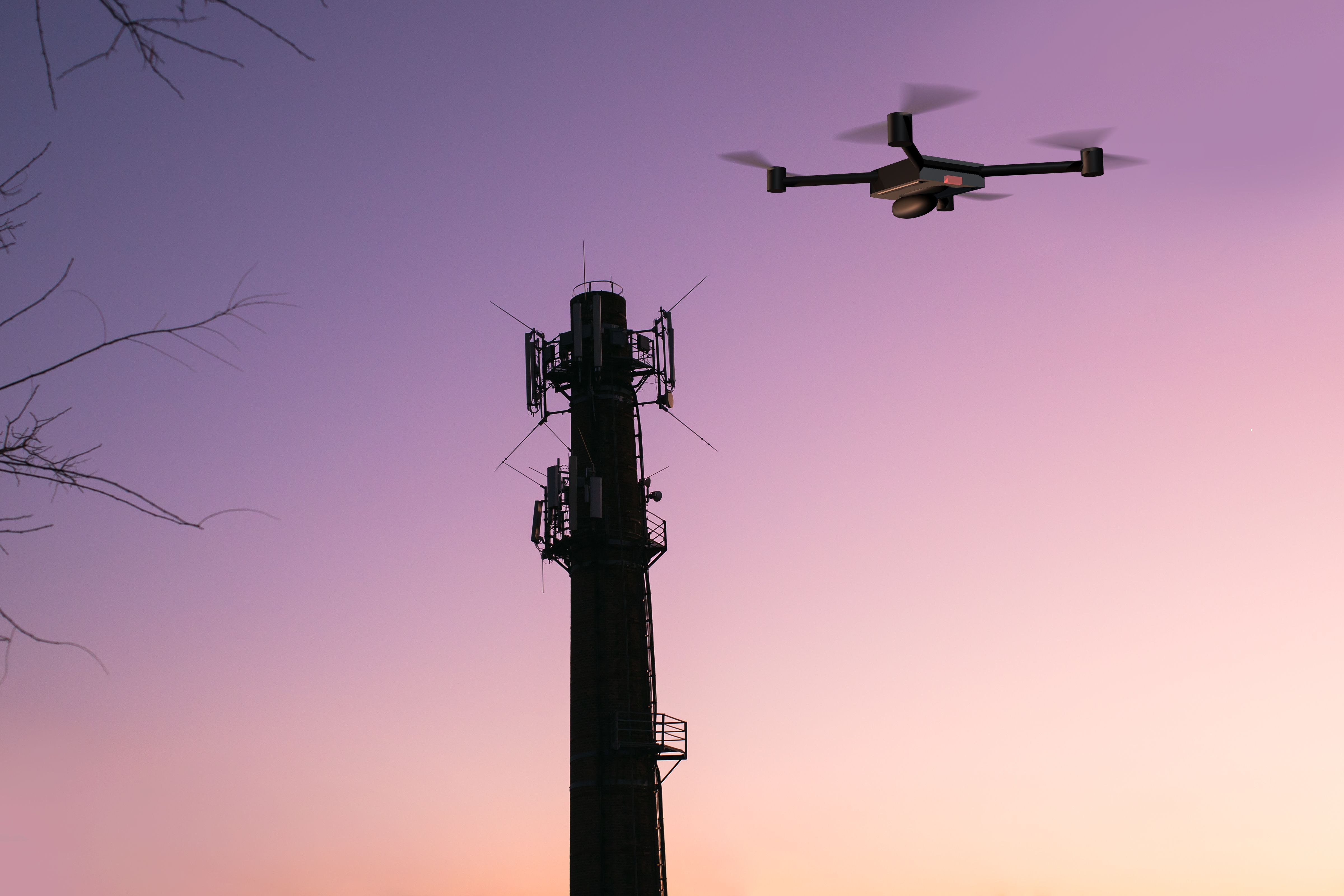 Manual drone near a cell tower in front of a pink sunset
