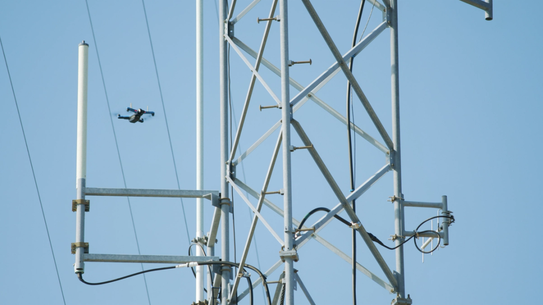 Skydio drone navigating between cell tower and power lines
