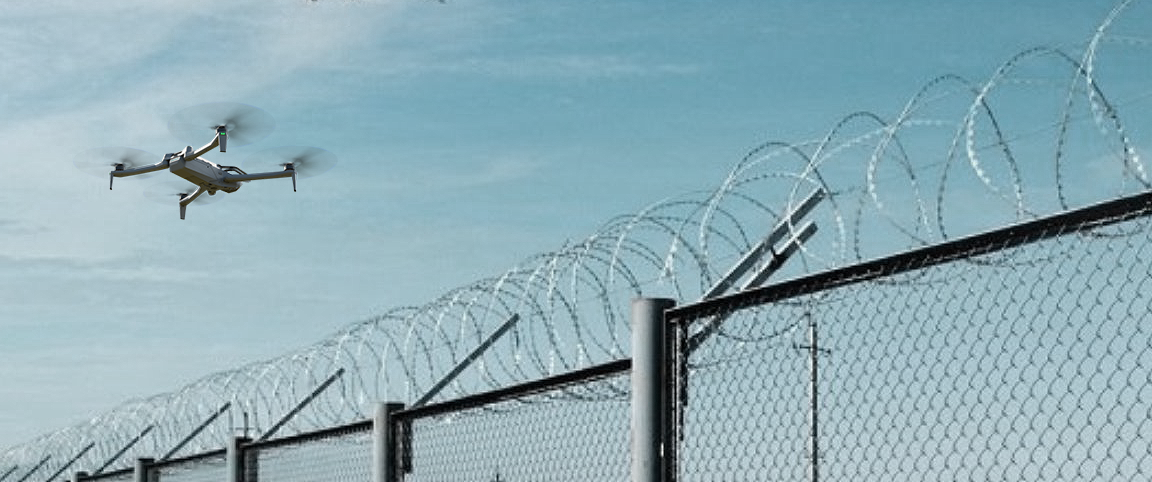 Skydio X10 drone flying over a razor wire fence, providing site security