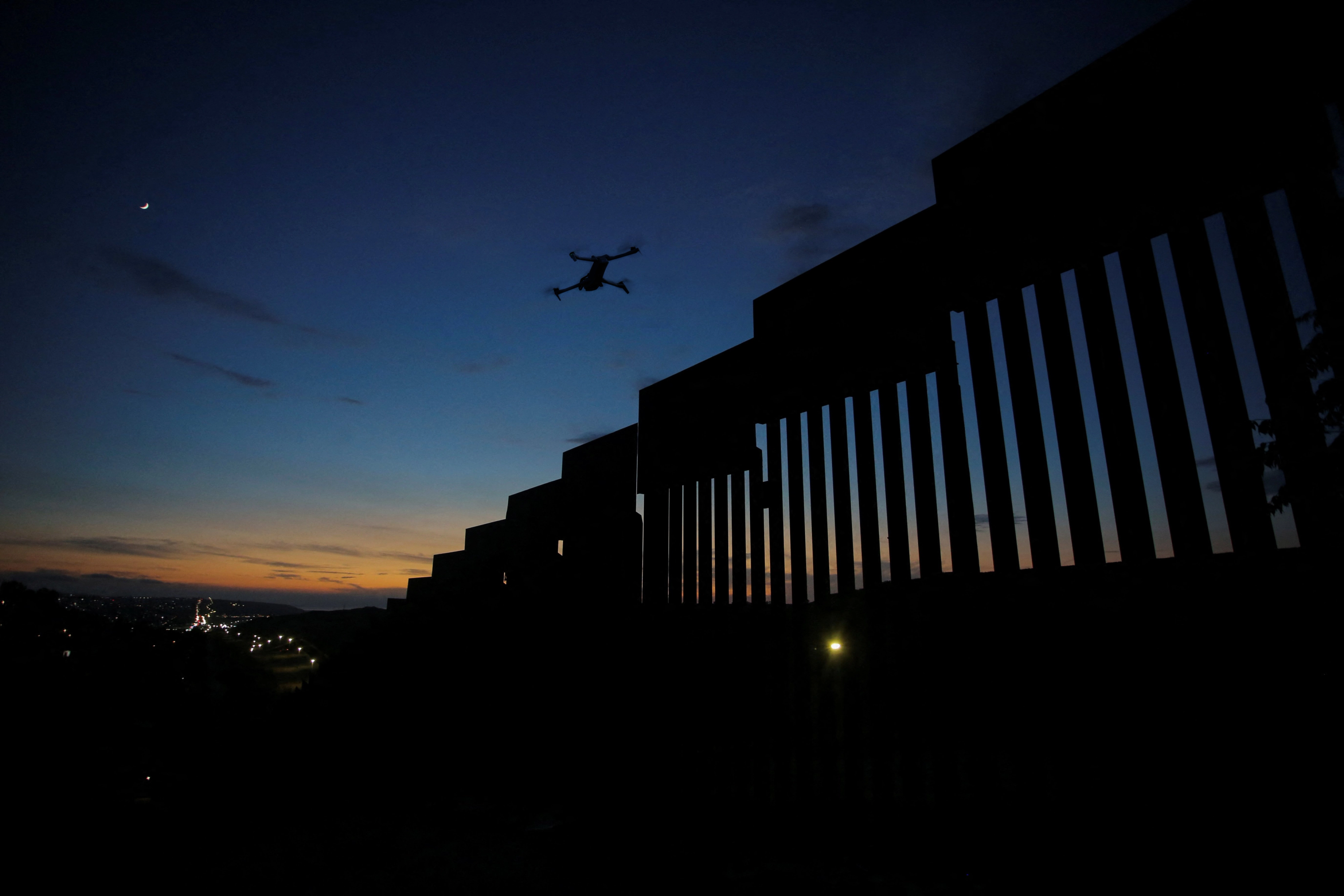 Skydio drone patrolling a border fence at dusk
