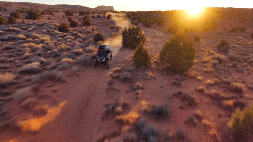 Skydio drone flying backwards near trees following tyler mccaul UTV