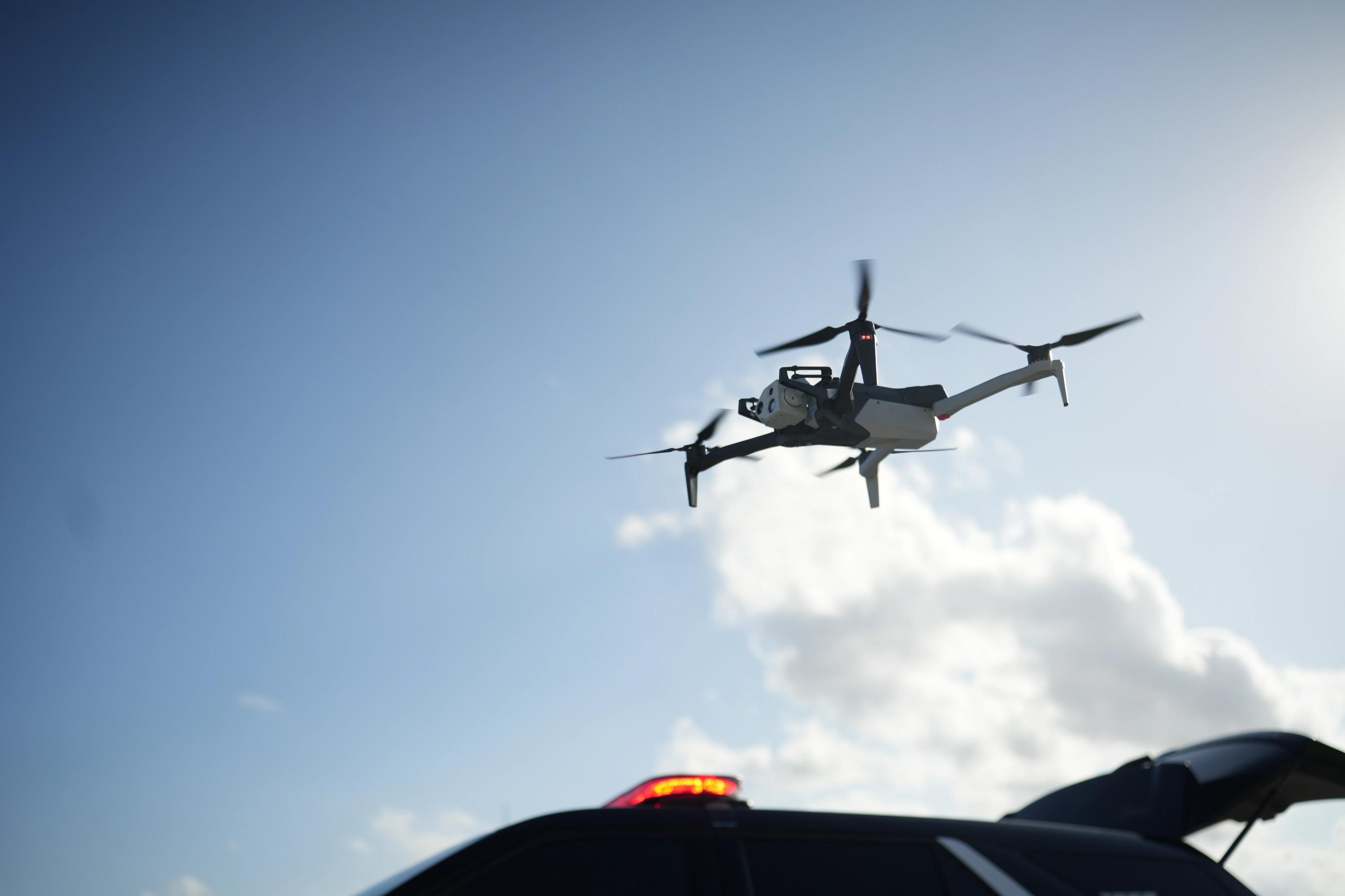 Skydio X10 in flight over patrol vehicle