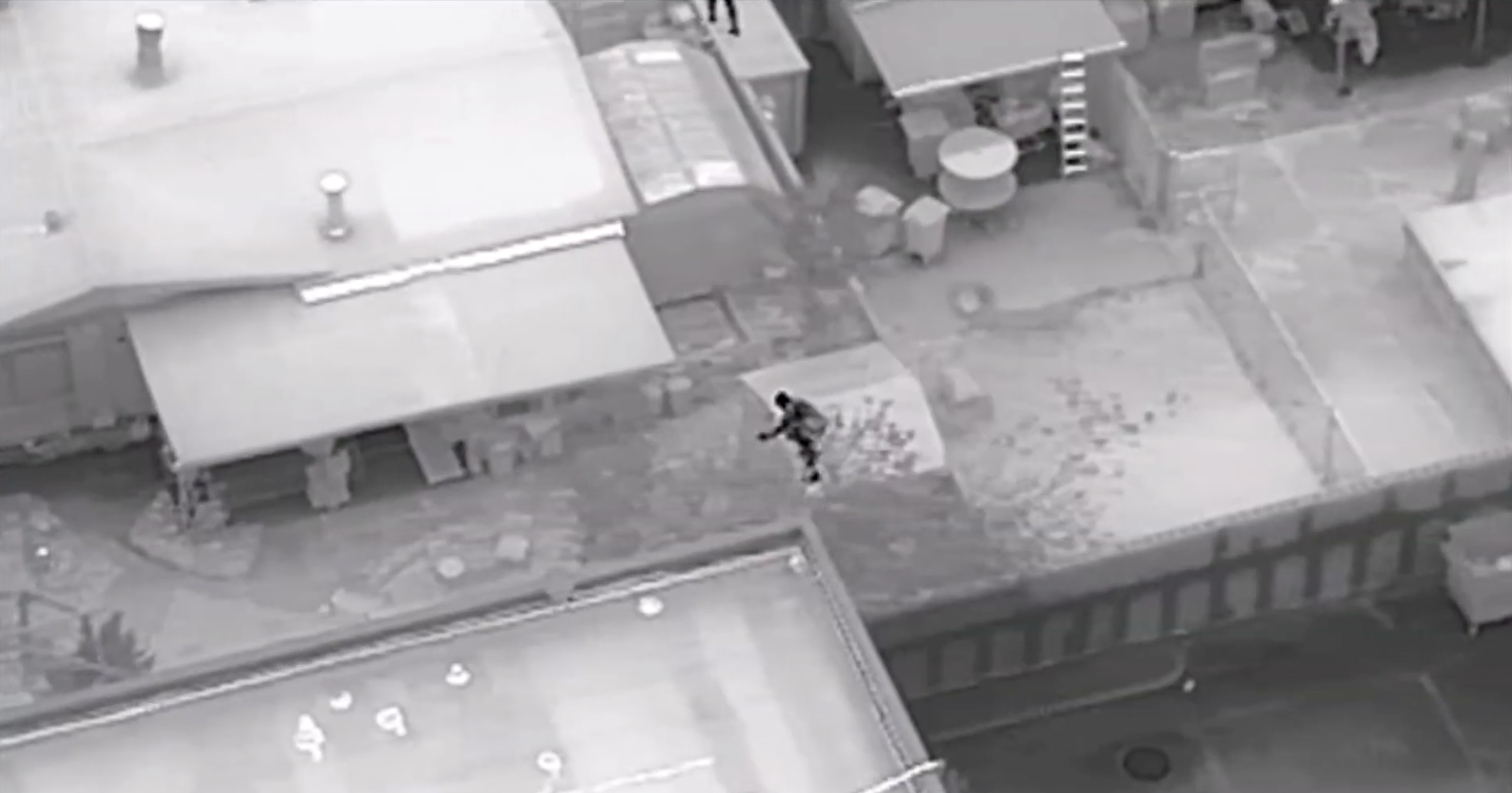 thermal image from Skydio X10 police drone showing a man jumping a fence between yards 