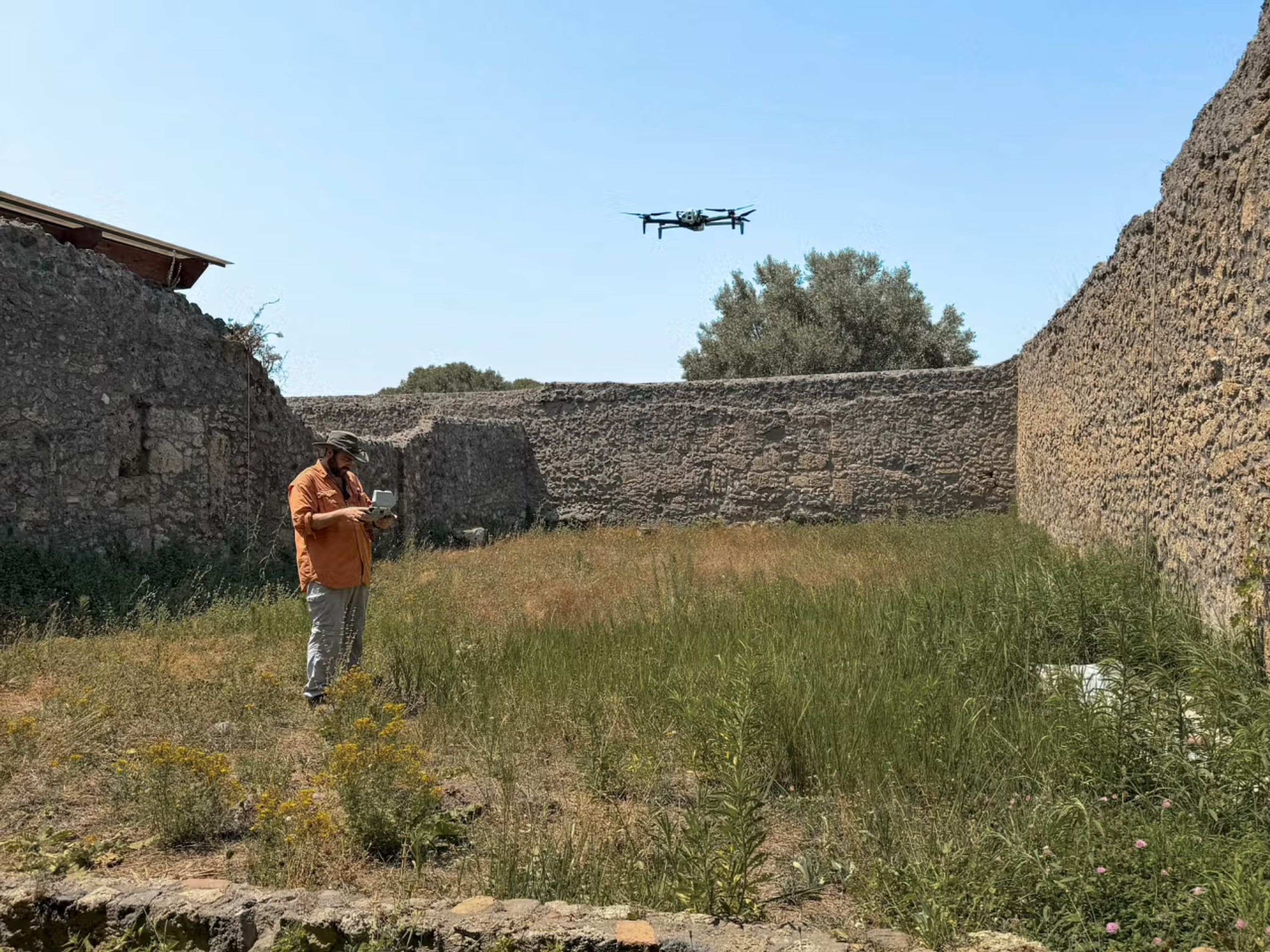 operator flying a Skydio drone to create digital twins of an insula (city block) within Pompeii.