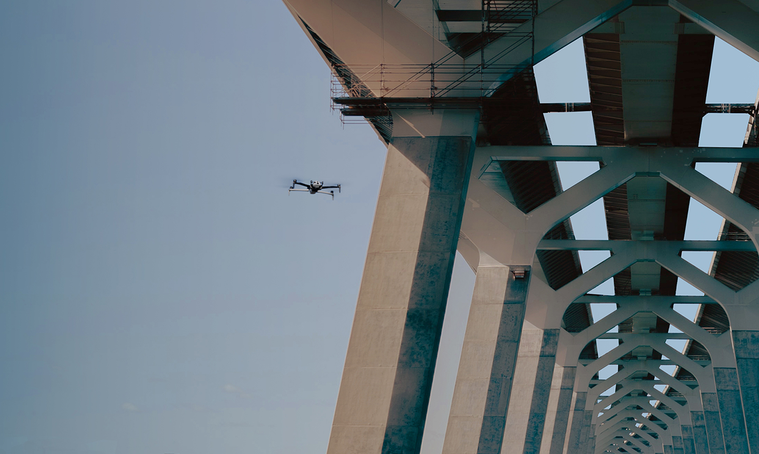 Skydio inspection drone on the underside of a tall bridge