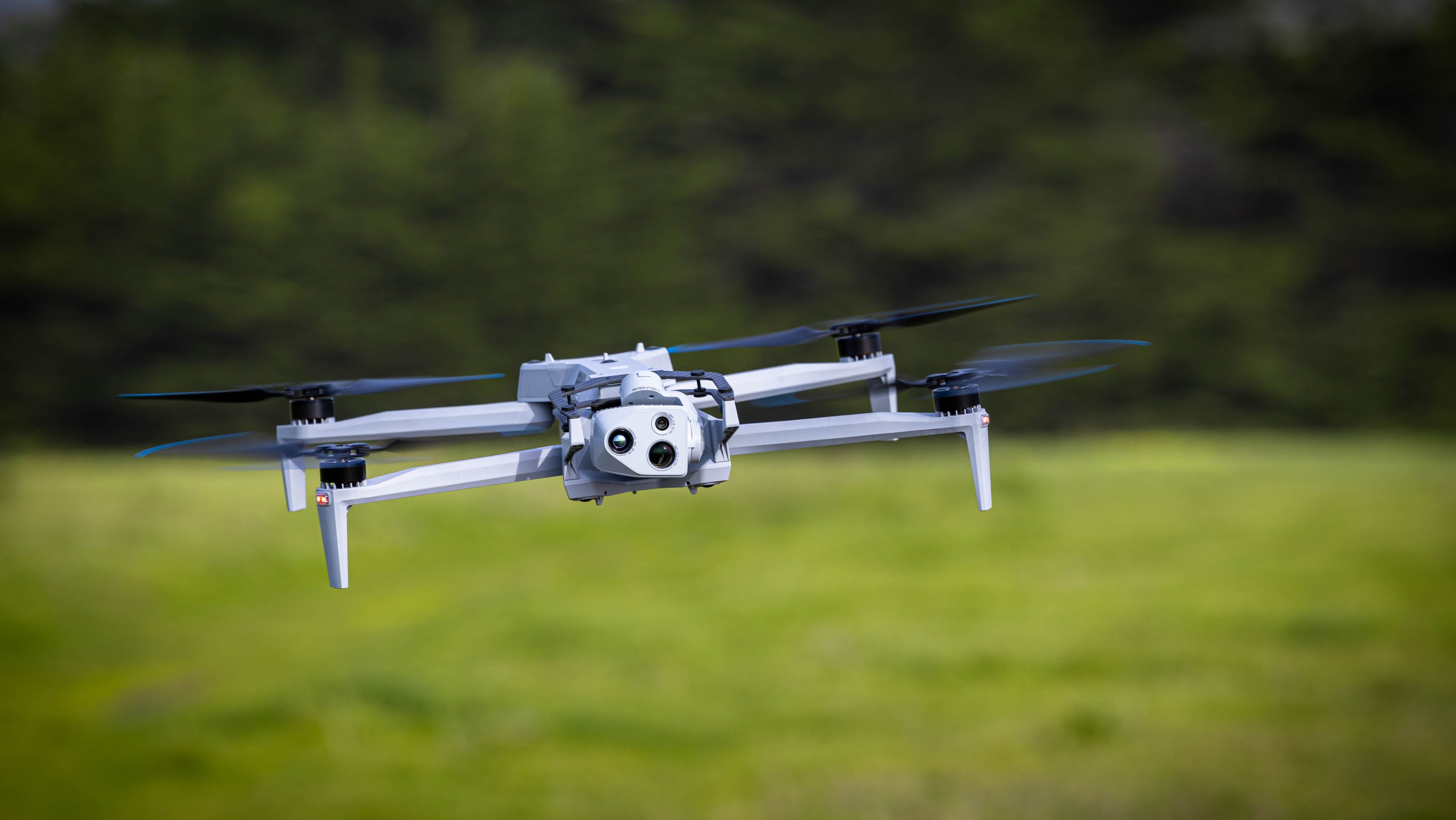 Skydio X10 in flight with grassy landscape. 