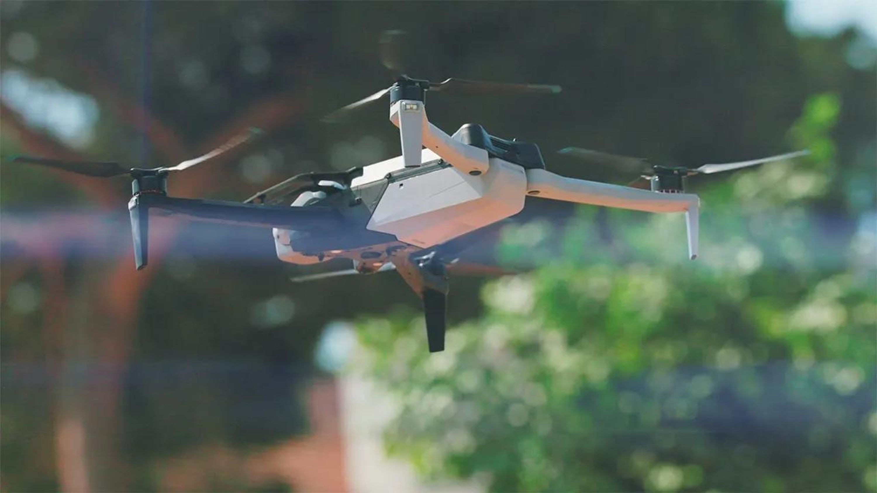 Skydio X10 drone in flight with greenery in the background