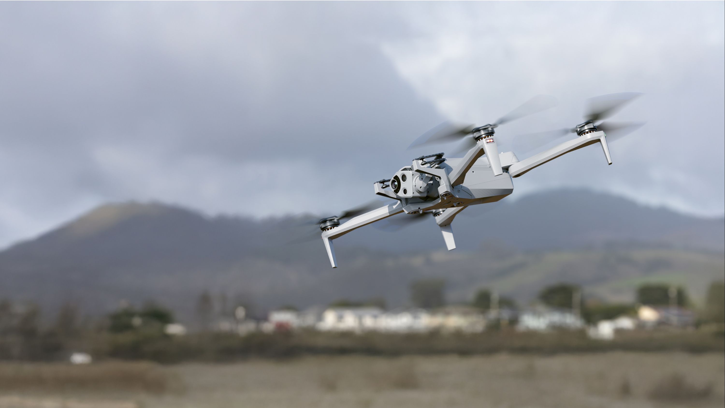 Skydio X10 in flight with hills in the background. 
