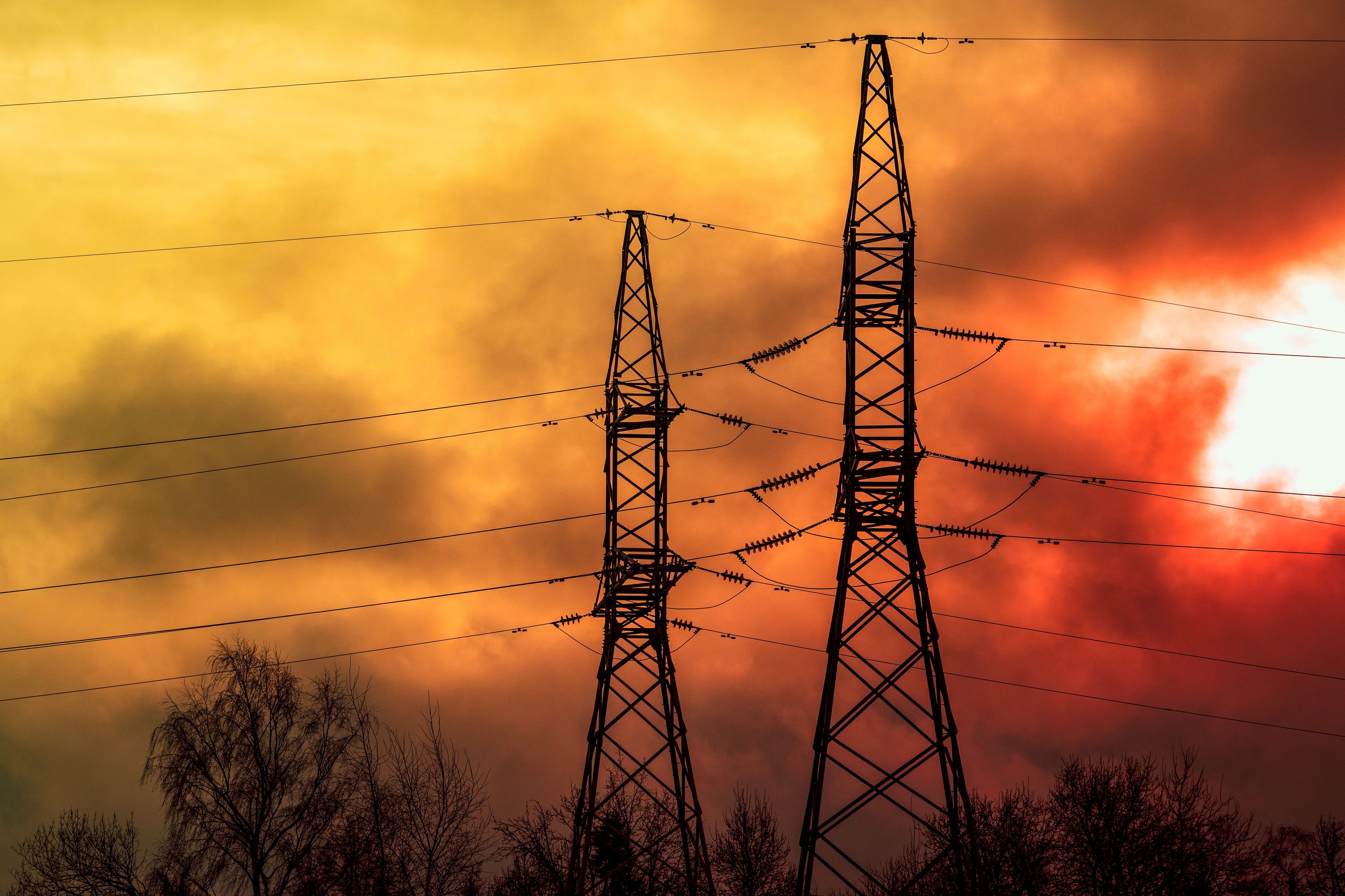  electric line towers with wildfire in the background