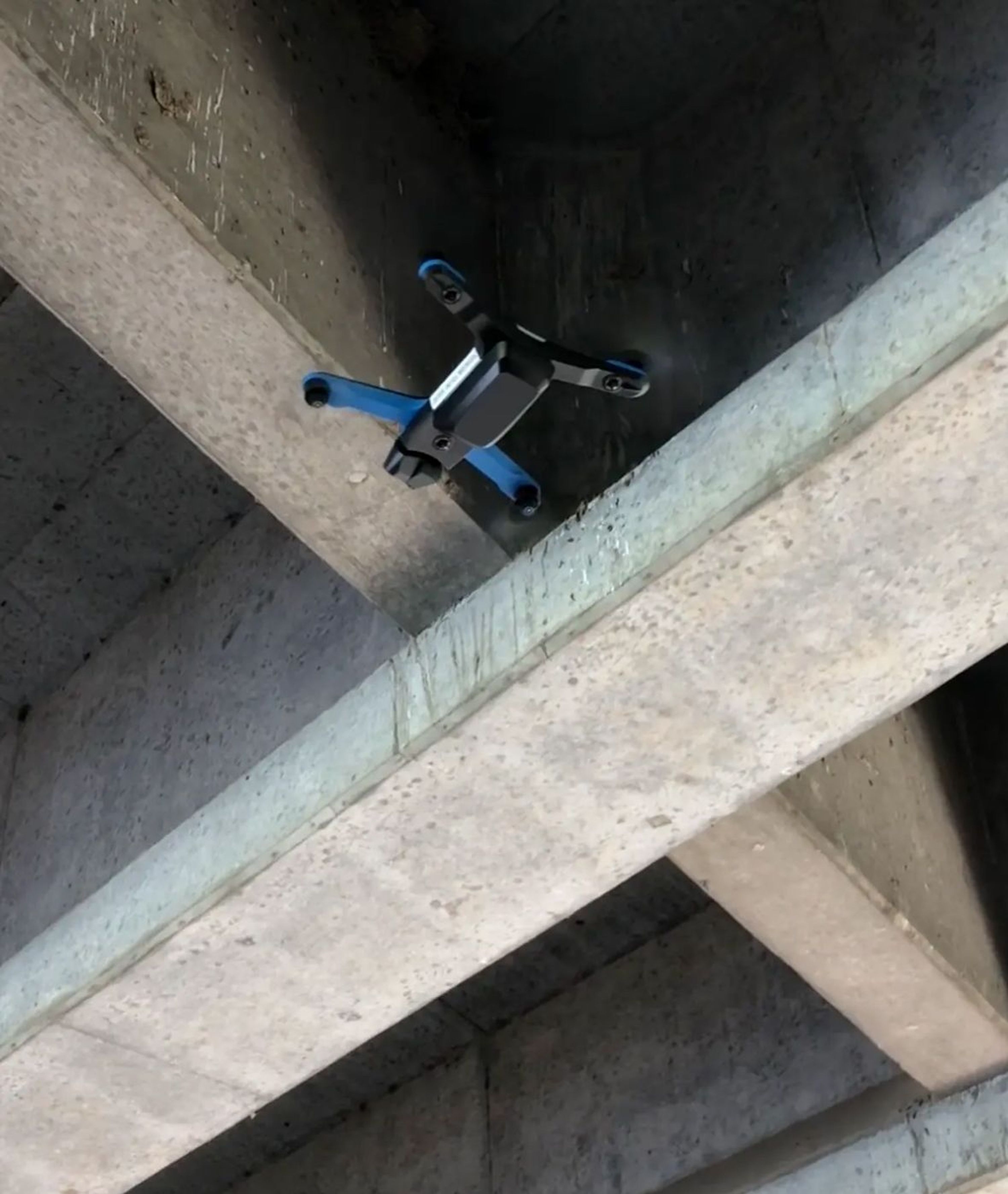 Skydio inspection drone flyingunder cement bridge support structure