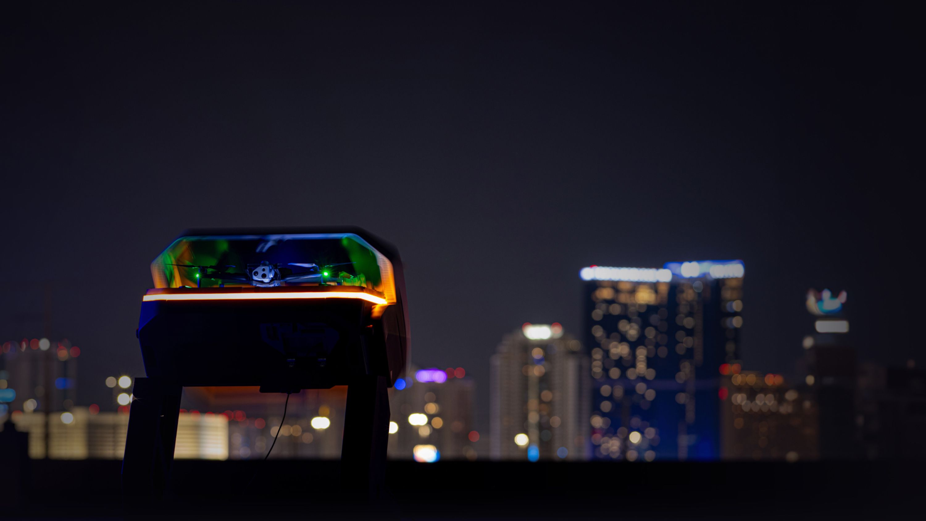 graphic of lit Skydio Dock for X10 with Skydio X10 drone inside, city in the background