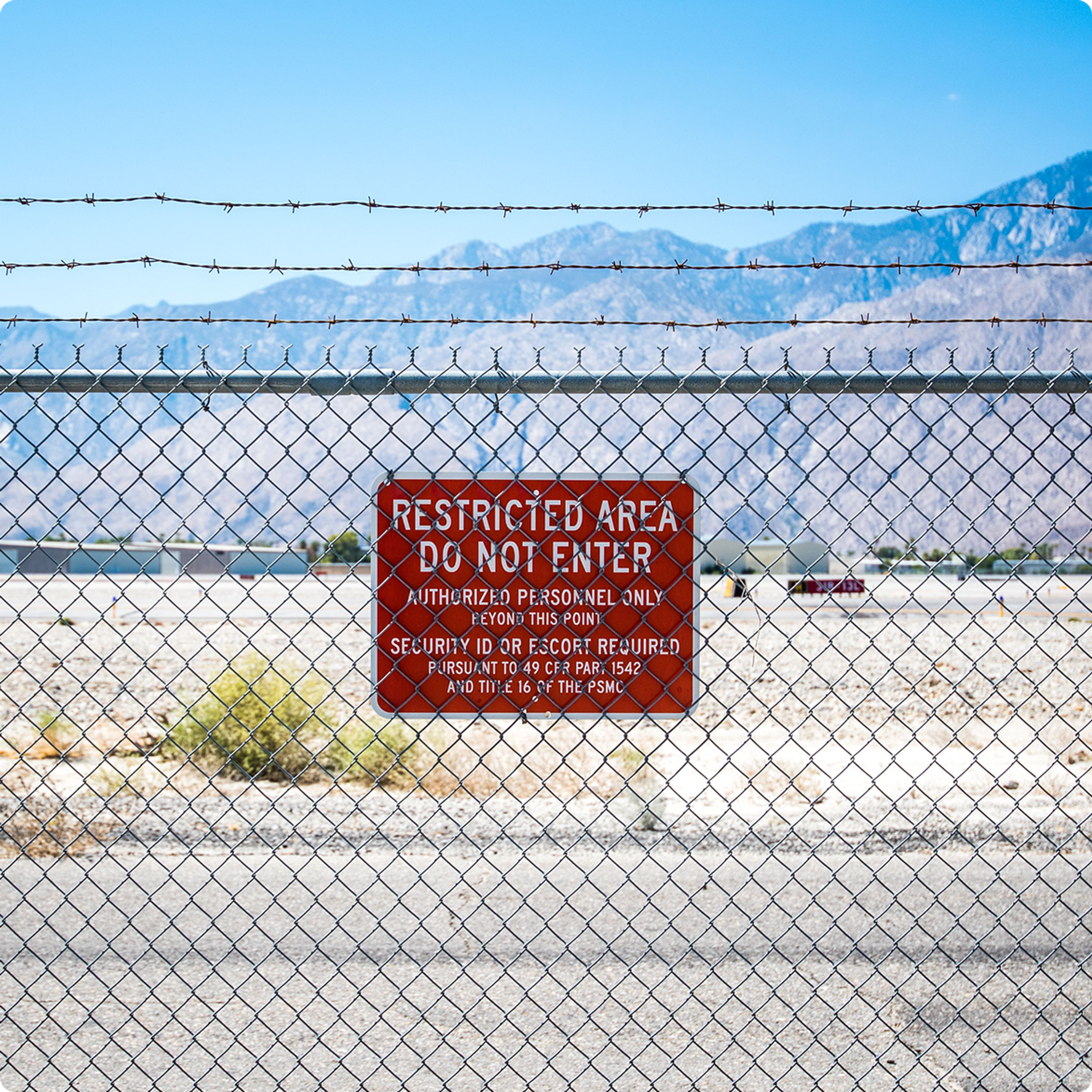 Old method of security,  showing military base perimeter fence with red restricted do not enter sign