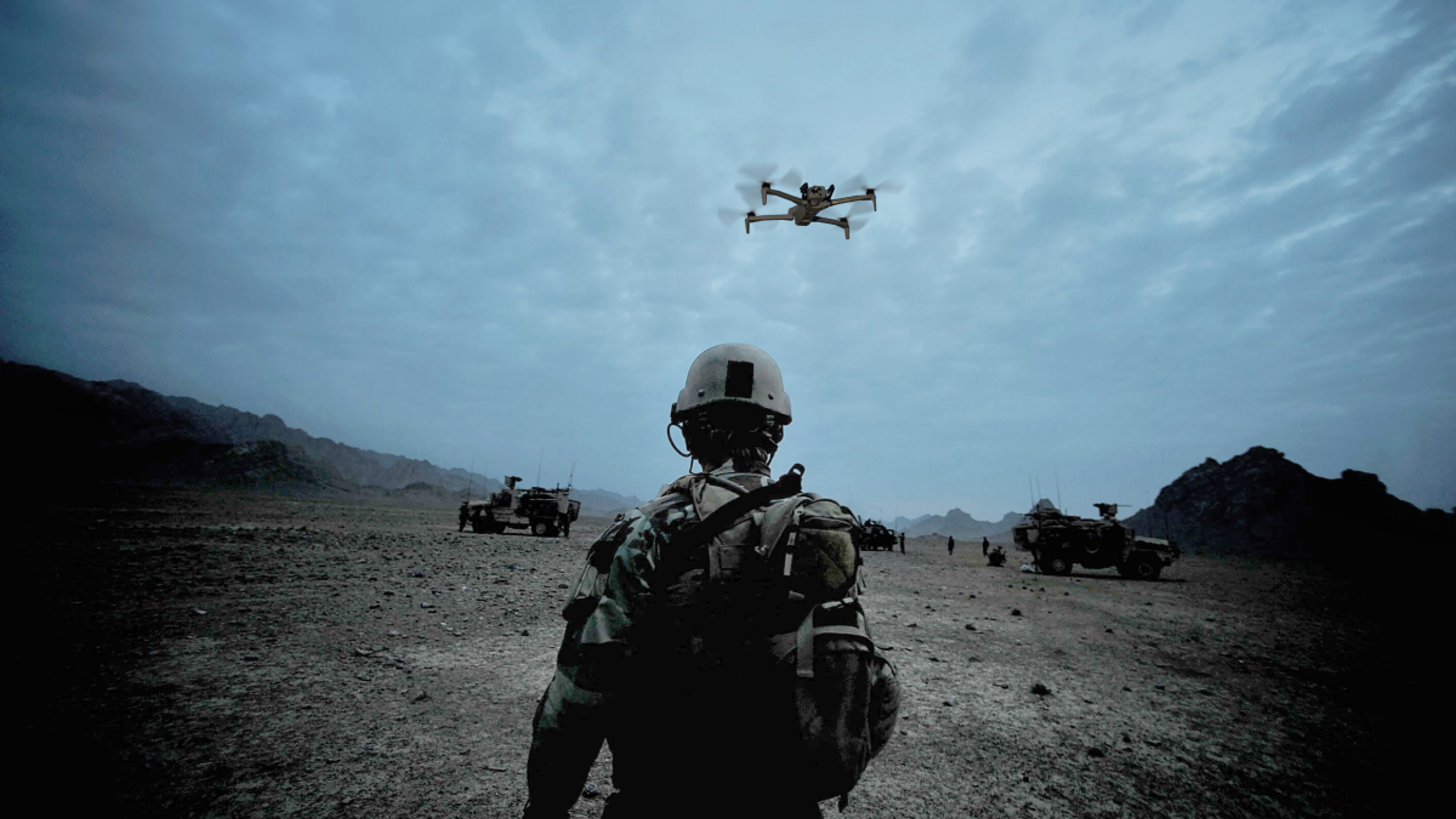 warfighters in desolate terrain with Skydio X10D UAS in flight overhead