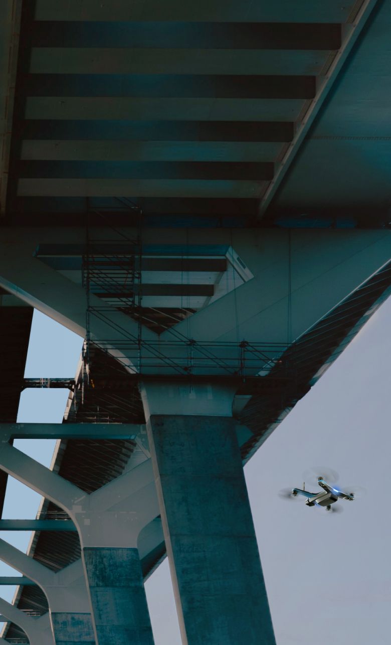 Skydio drone flying underneath a bridge