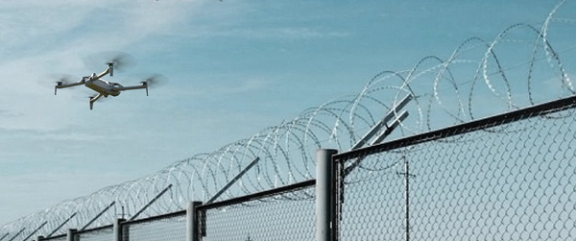 Skydio X10D drone inspecting perimeter fencing at military base 