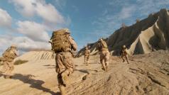 Five soldiers facing away from the camera, wearing full gear and helmets and running on a large sandy area