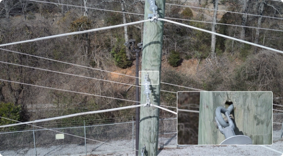 photo of powerline pole with focus on a weak point in the attachment of the line