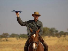 Friedrich monitoring wildlife from horseback, holding the Skydio 2.