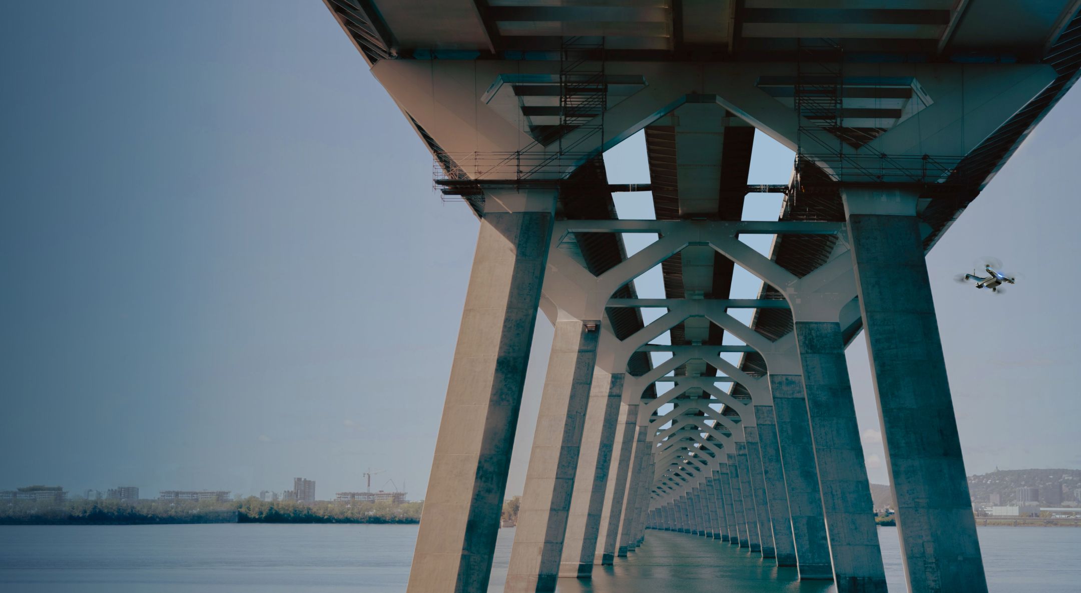 Wide view of a Skydio drone flying under a bridge