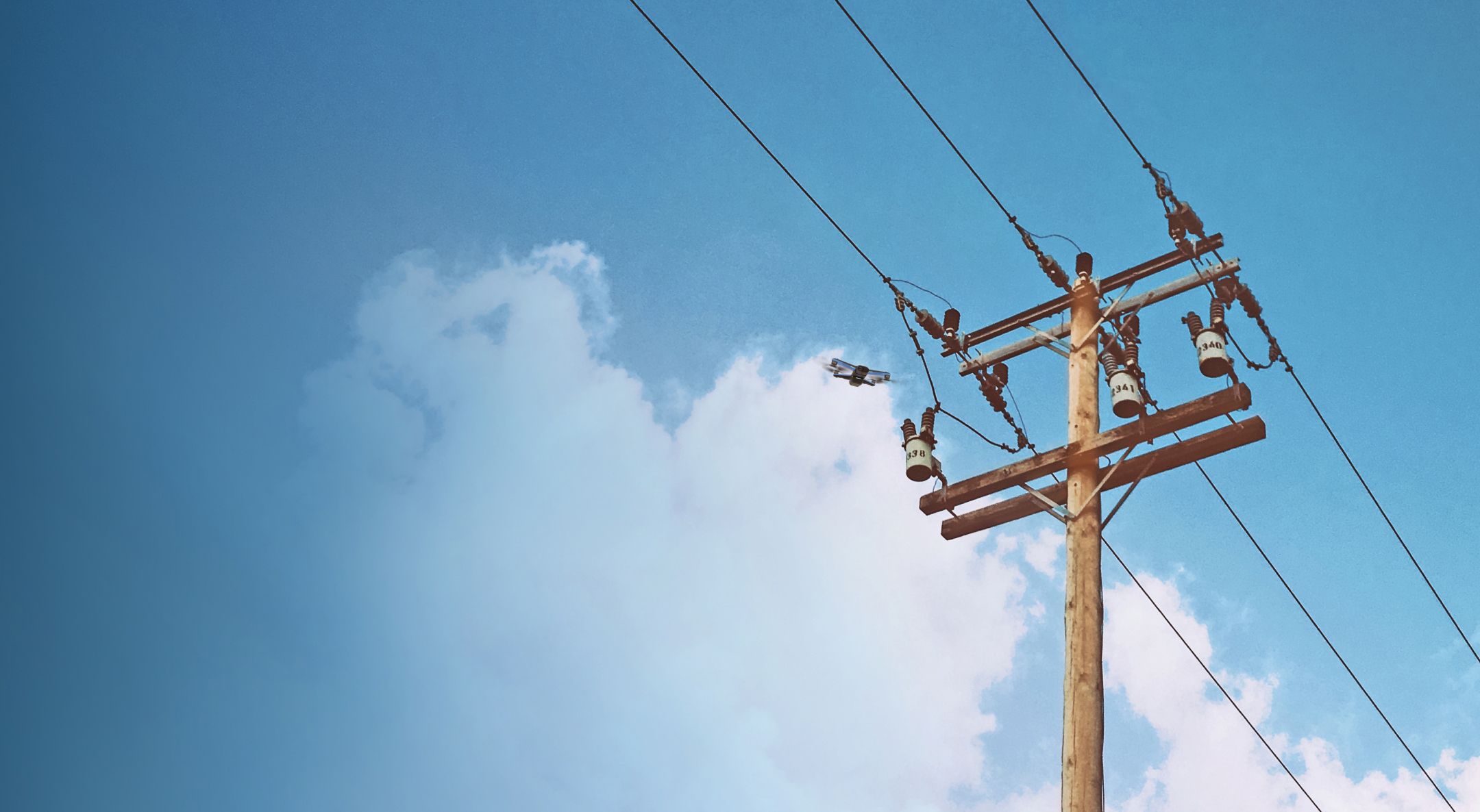 Wide view of Skydio drone flying around a power line