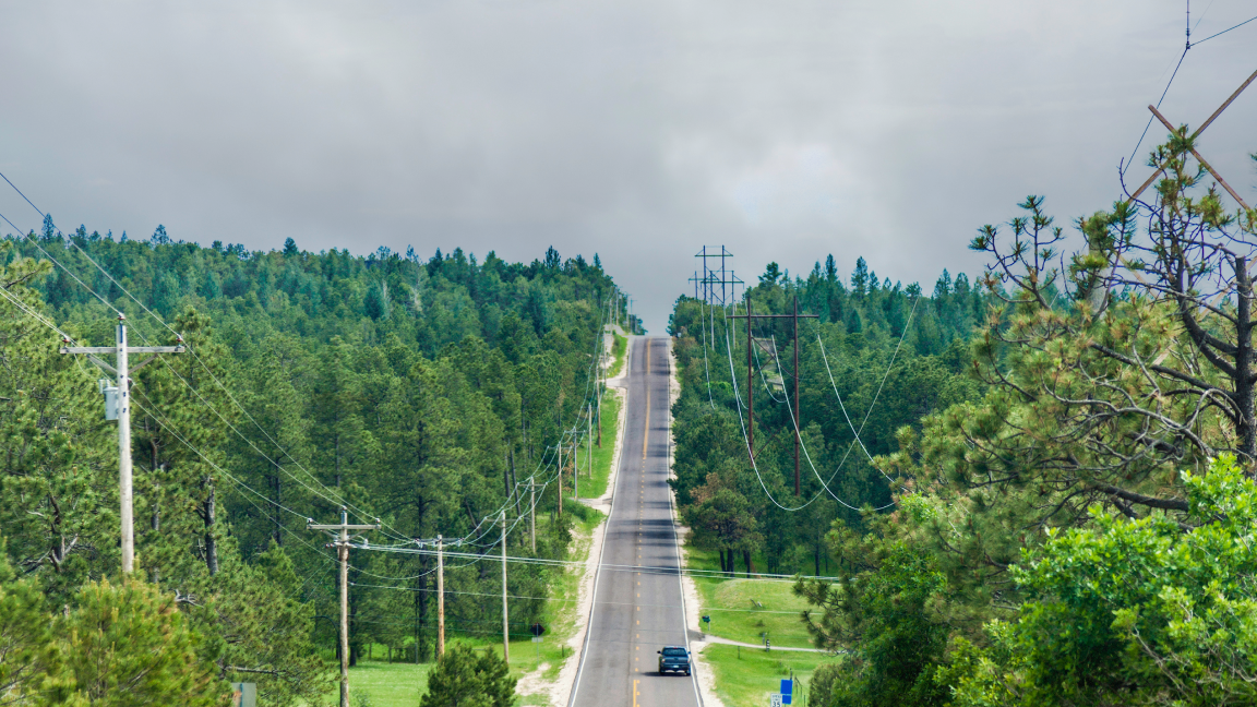 road with many utility pylons stretched alongside the road