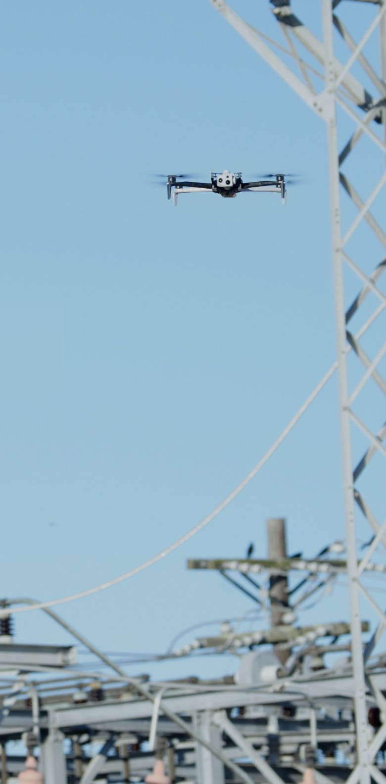 portrait view of a Skydio drone flying in a power substation location