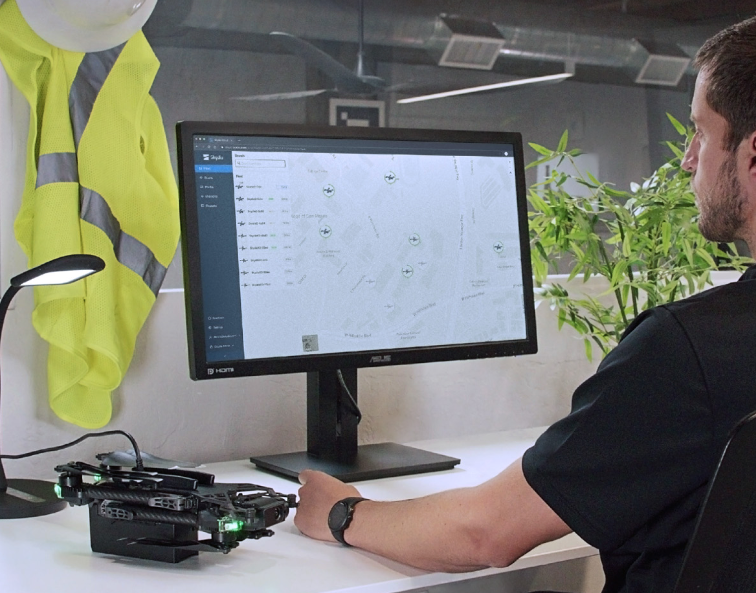 A enterprise customer associate working on a desktop computer, connected to a Skydio X2 drone.