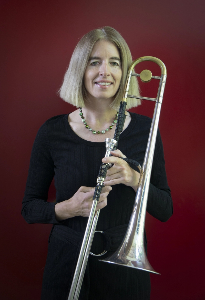 Marion Dimbath mit Posaune vor rotem Hintergrund