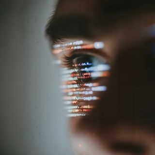 Close-up of an eye reflecting colorful computer code