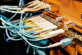 Back of a server rack with cables extending out.