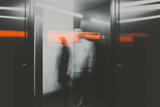 Abstract photo of blurred figures in motion with a striking orange light streak