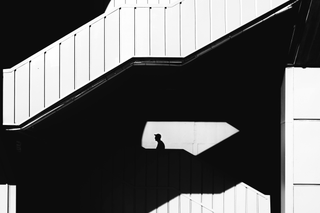 Silhouette of man behind wall on stairs