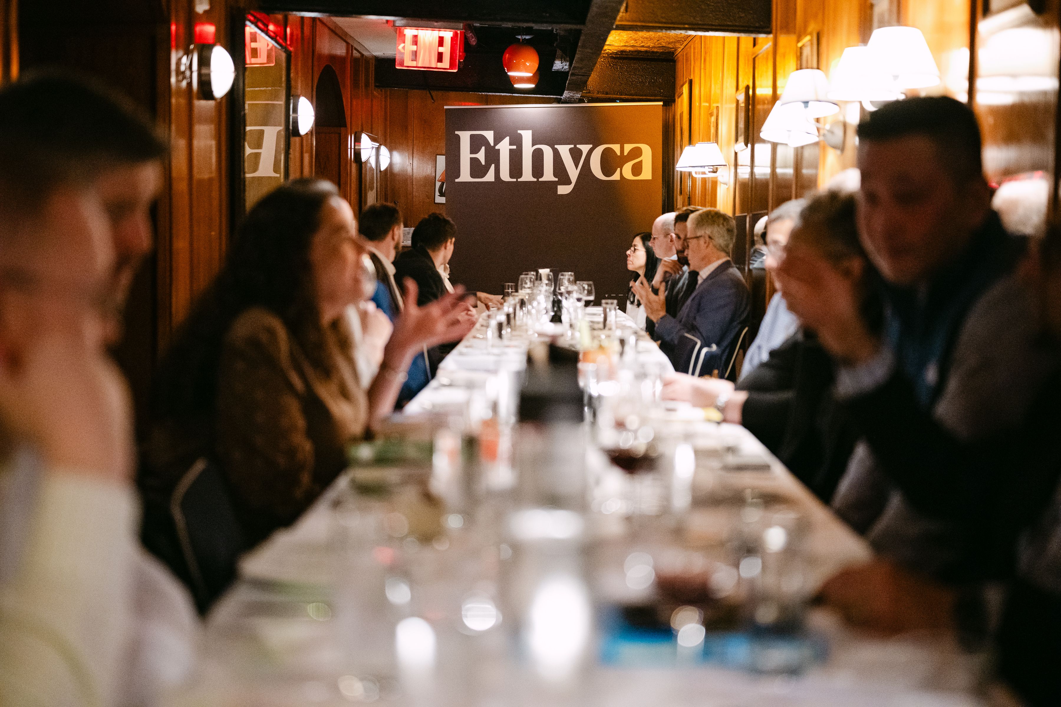 People sitting around a table in front of an Ethyca banner.
