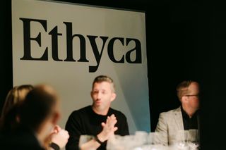 People sitting around a table in front of an Ethyca banner.